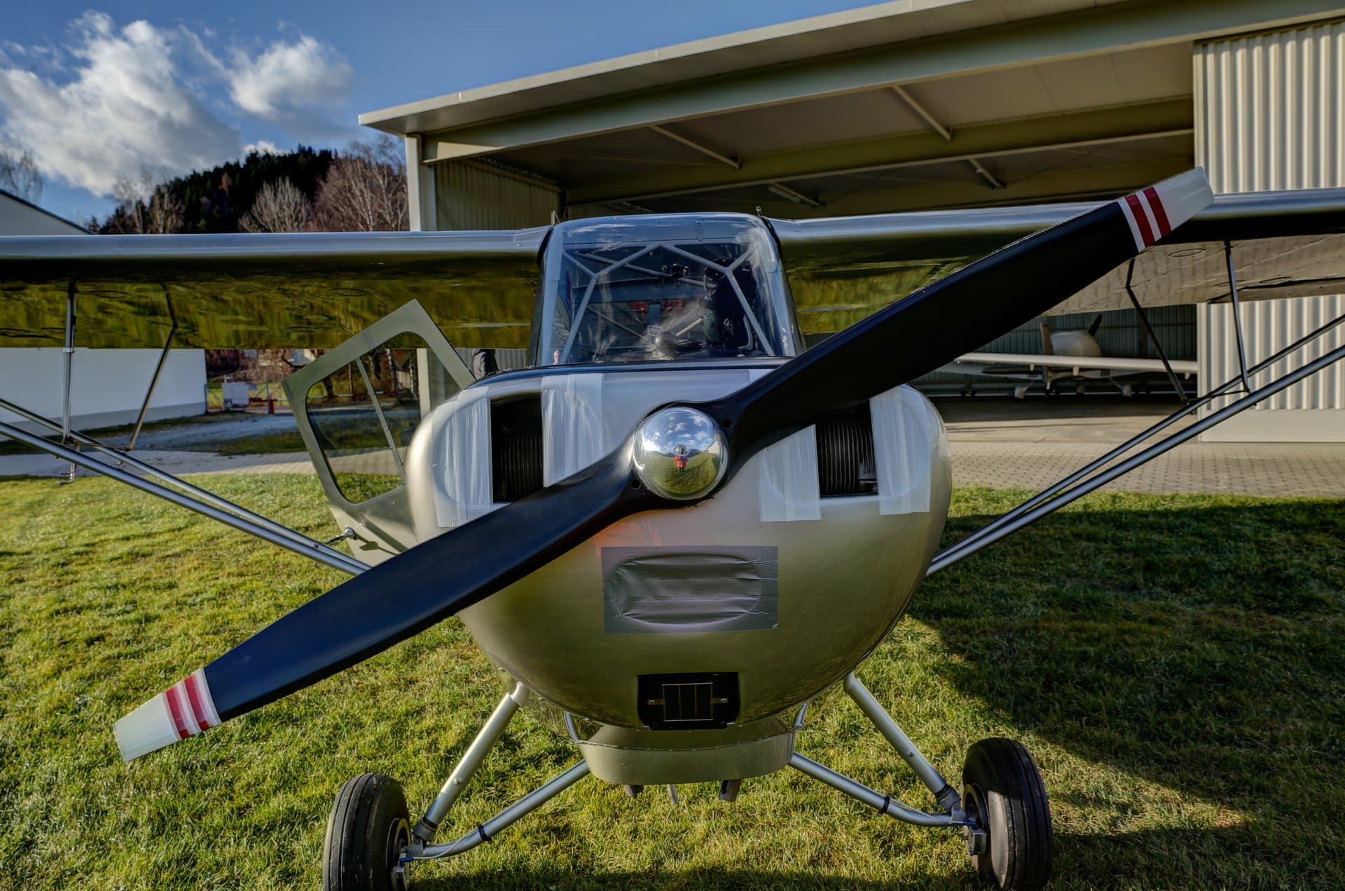 A restored olive-drab Aeronca L-16, model 7BCM, parked on grass at Feldkirchen, Austria