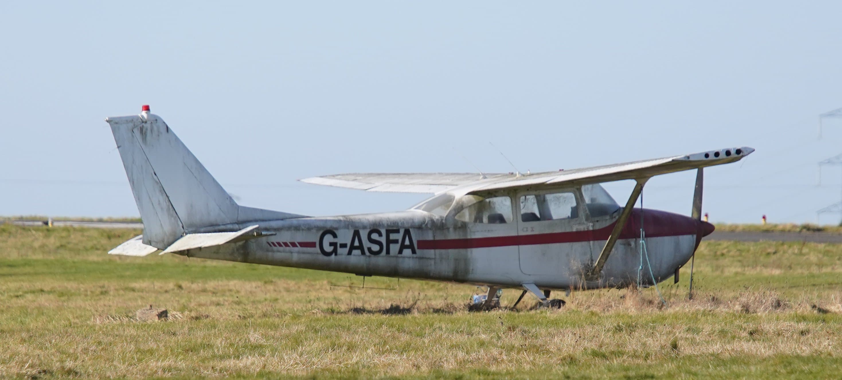 Un Cessna 172D Skyhawk patiné, stationné dans un champ