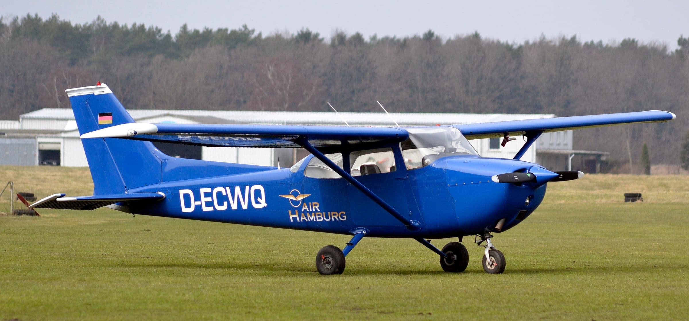 Un Cessna 172 Skyhawk aux couleurs bleu foncé sur un terrain en herbe