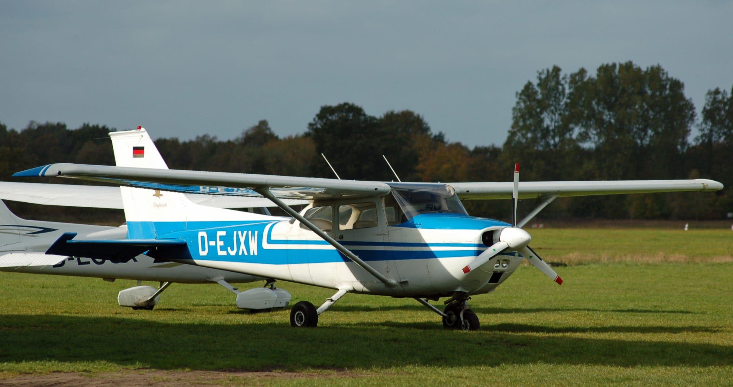 Un Cessna 172 Skyhawk bleu et blanc stationné sur l’herbe