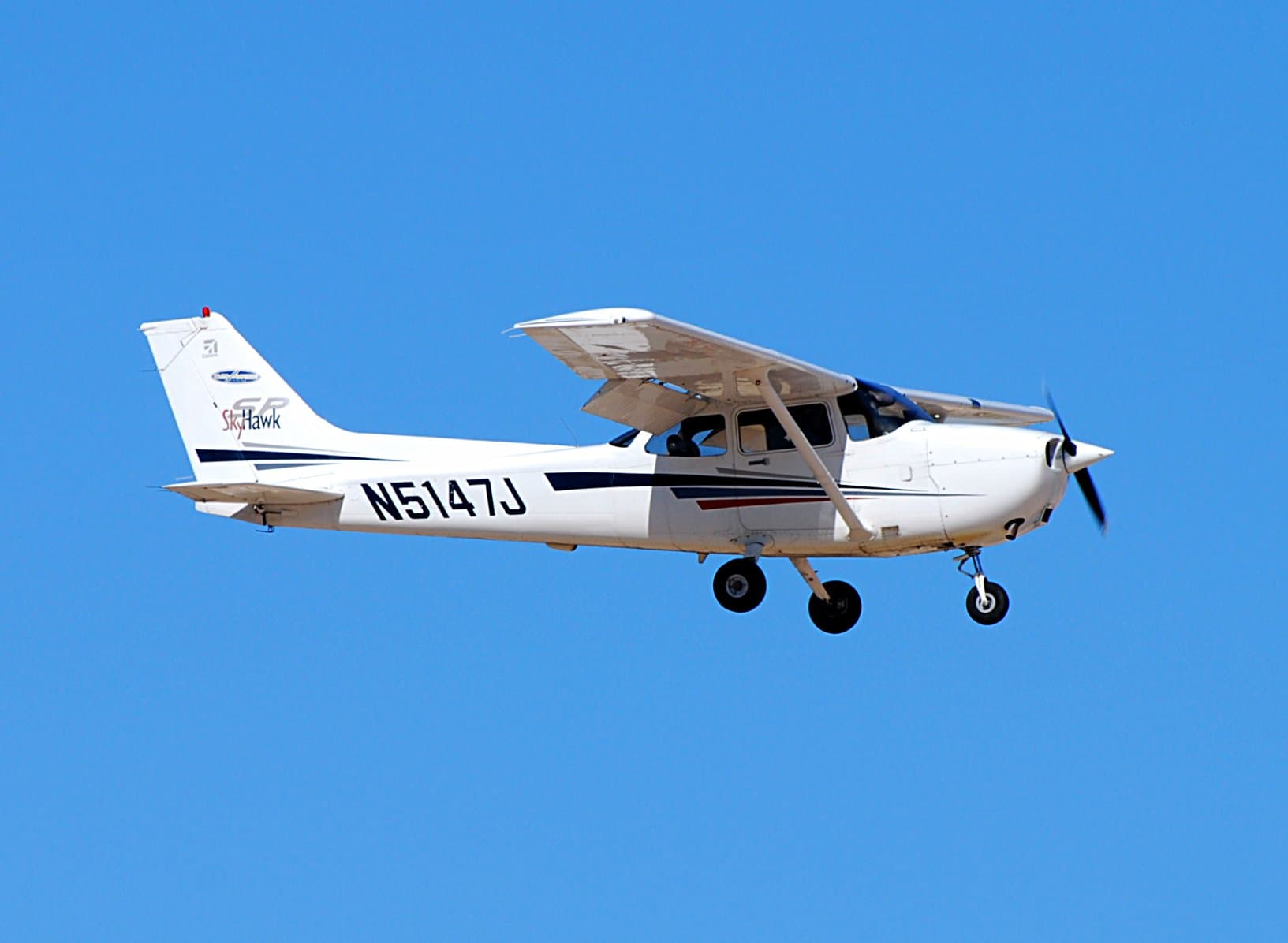 Cessna 172S Skyhawk SP in flight against a clear blue sky