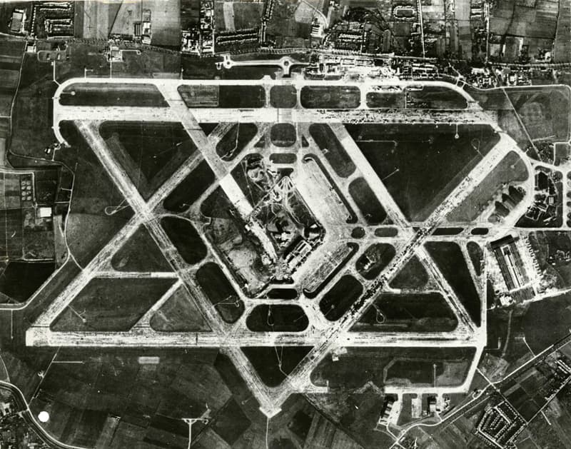 Vertical aerial photograph of Heathrow in 1955, showing the six-runway Star of David pattern with the central area building site at its heart