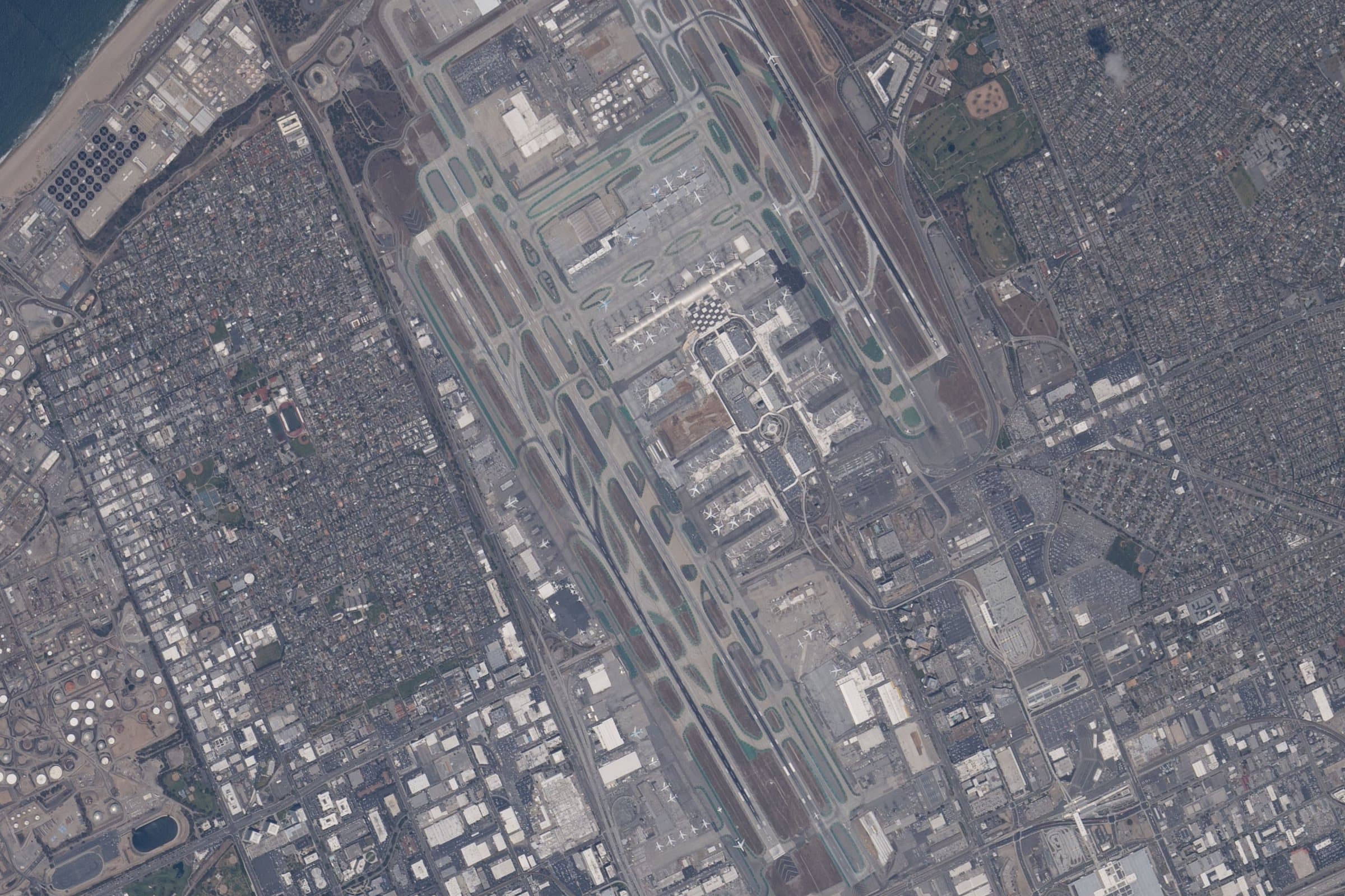 LAX seen straight down from the International Space Station in May 2026: two pairs of parallel runways run east-west, with the U of terminals between them