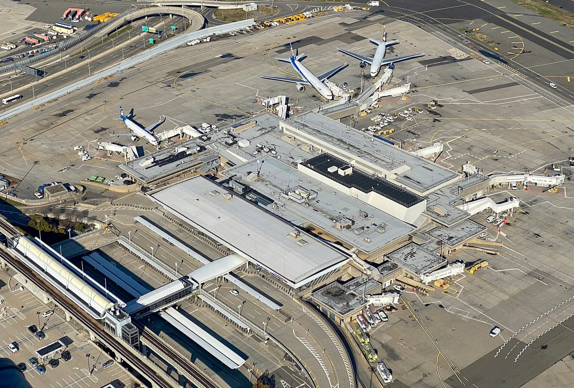 Terminal 7 from the air in November 2020, the low 1970 building with aircraft at its pier and the AirTrain loop beside it
