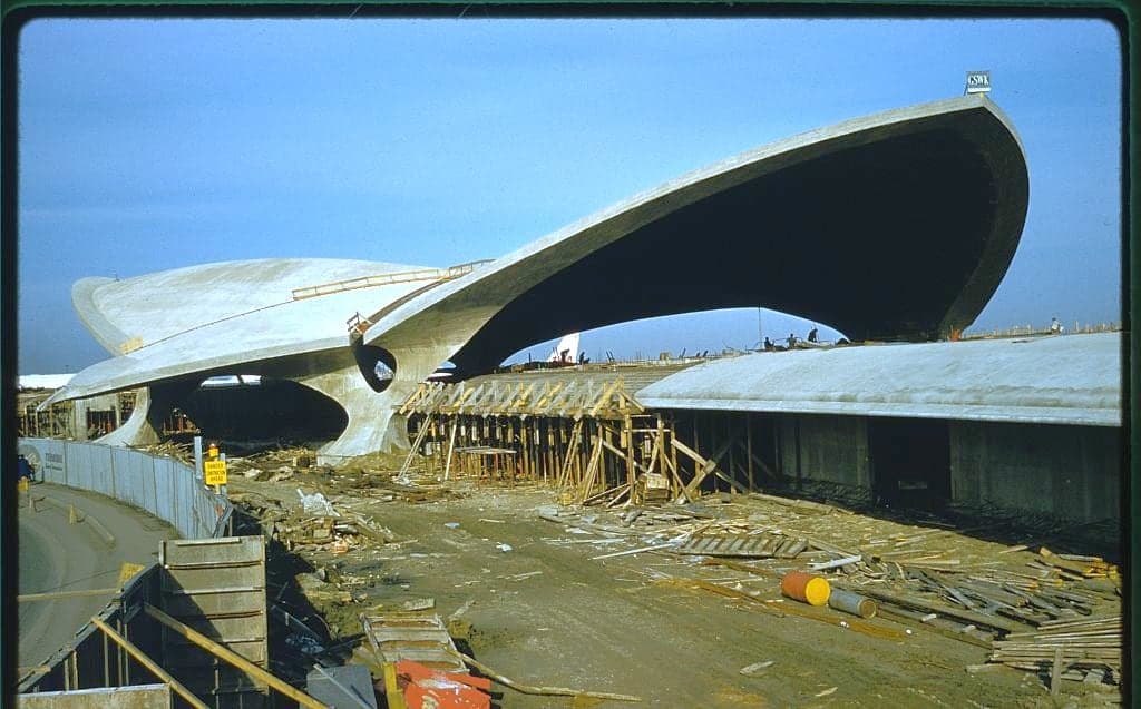 The TWA Flight Center under construction in 1962, its concrete wing-shaped roof shells complete and timber formwork still piled below