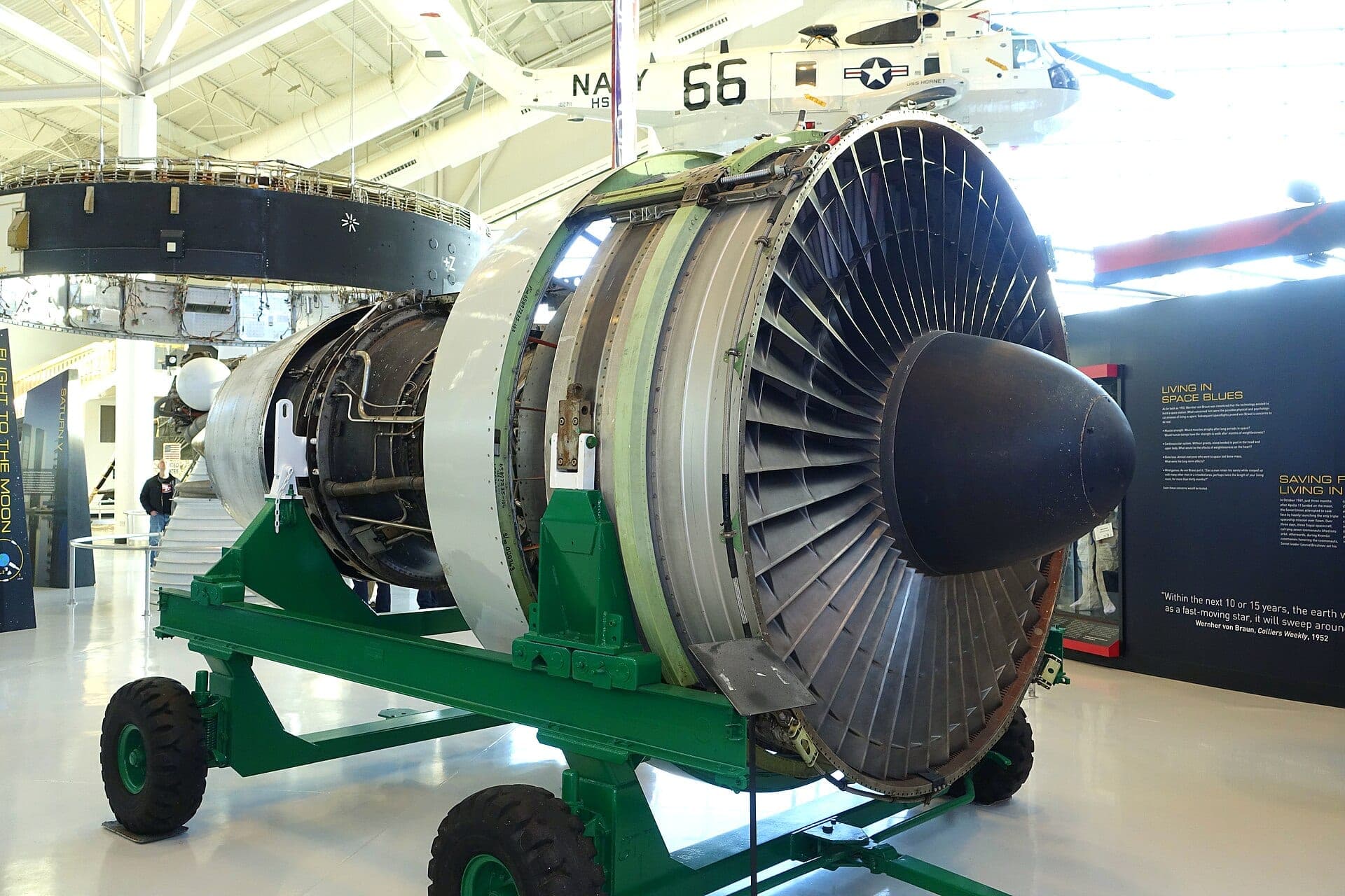A complete Pratt & Whitney JT9D on a green transport stand at the Evergreen Aviation & Space Museum, fan and spinner facing the camera with the core casing behind