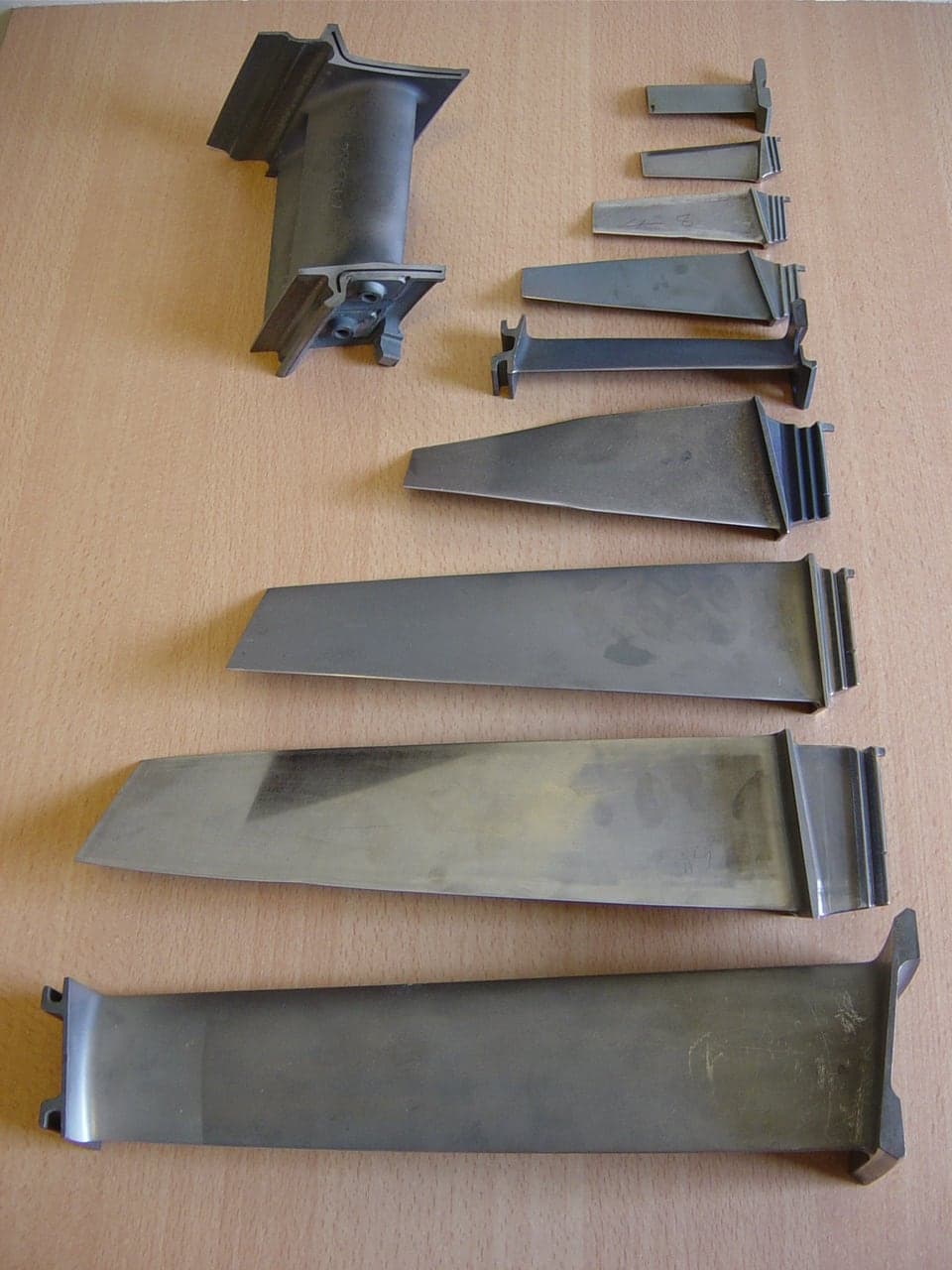 Olympus 593 compressor blades and vanes laid out in order of size, from the long early-stage blades to the small rear-stage ones