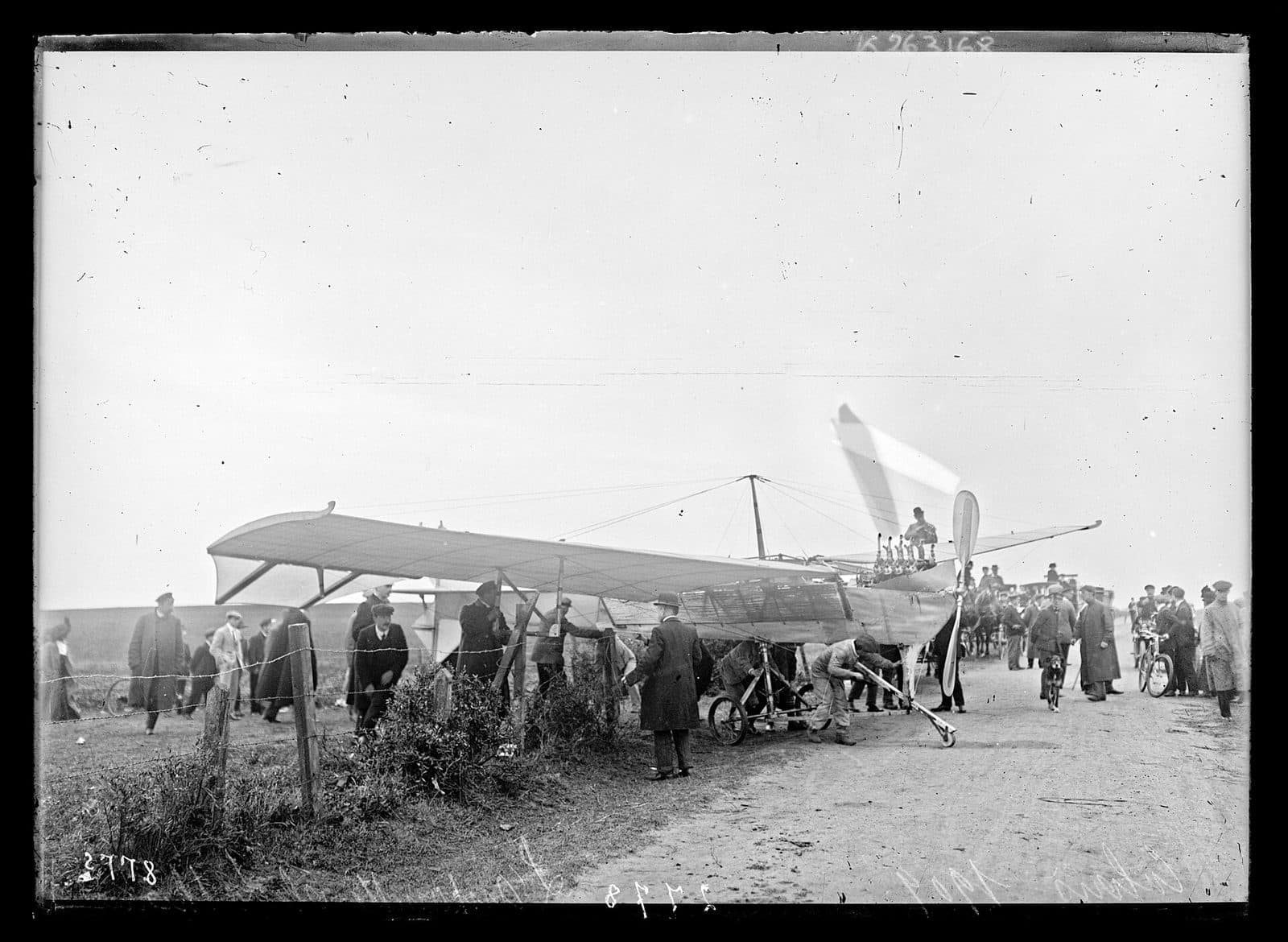 Hubert Latham's Antoinette monoplane on the ground at Sangatte, its long fuselage surrounded by onlookers.