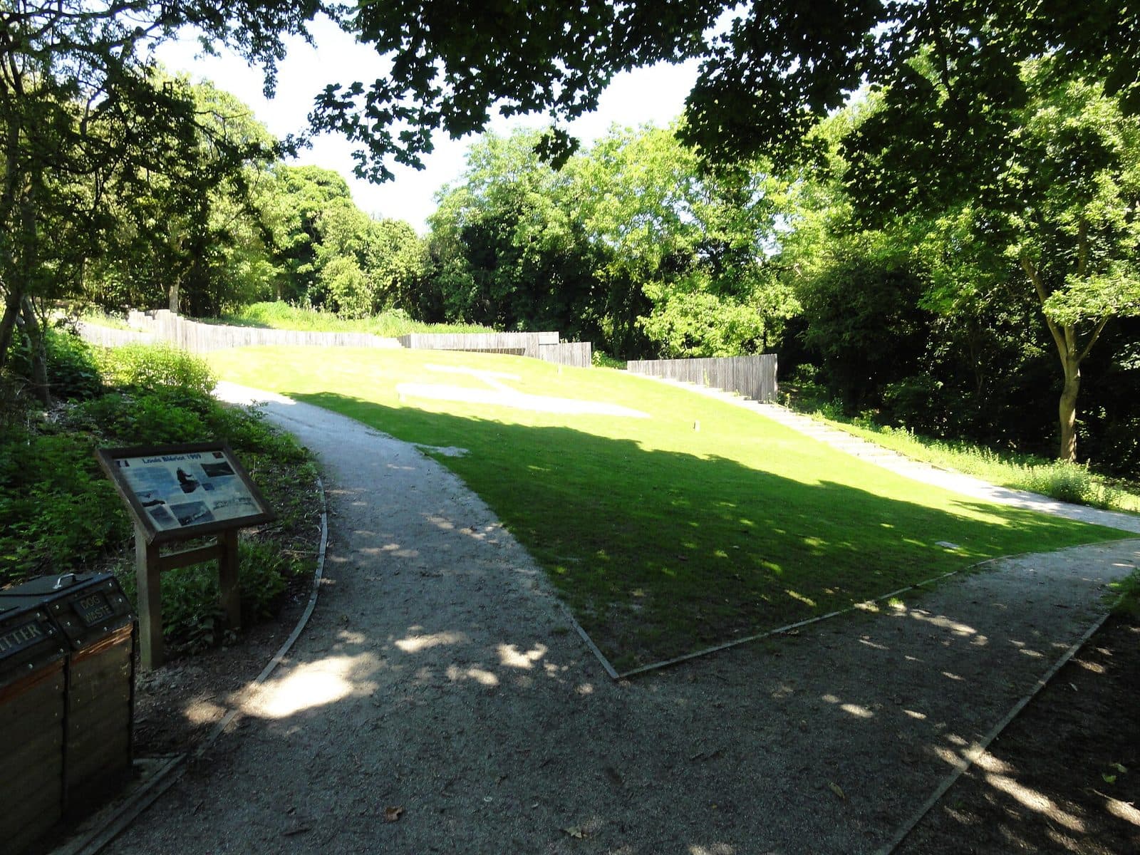 The Blériot Memorial at Dover today: the outline of the monoplane set in granite in a grass clearing among trees.