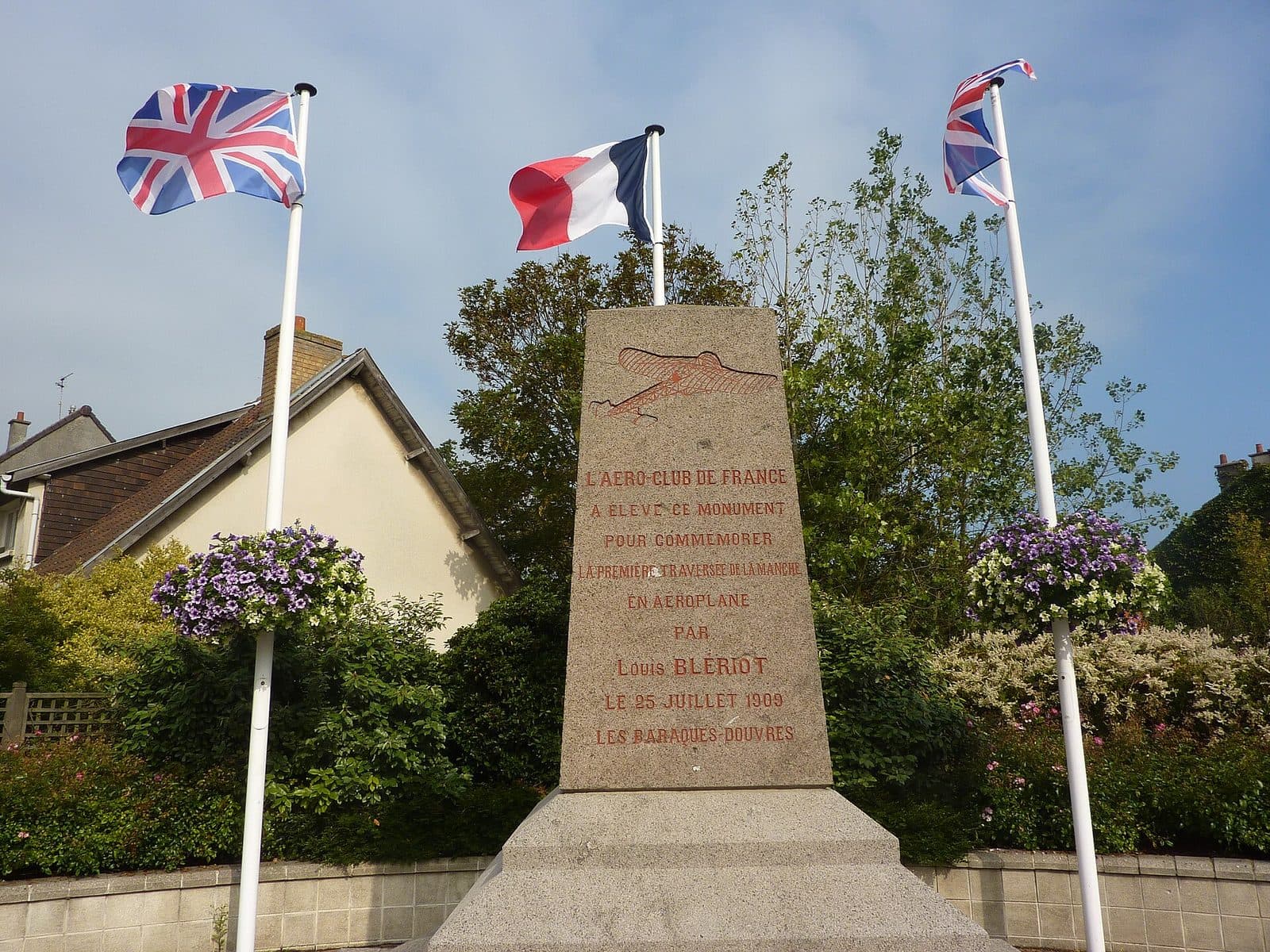 The stone monument to Louis Blériot at Sangatte-Blériot-Plage, flanked by the British and French flags.