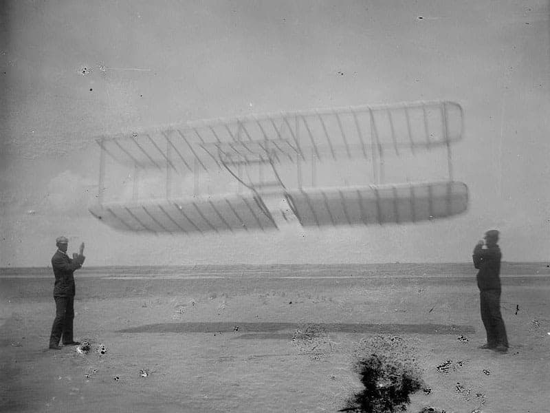 The 1901 Wright glider on the sand at Kitty Hawk, Wilbur at the left and Orville at the right.