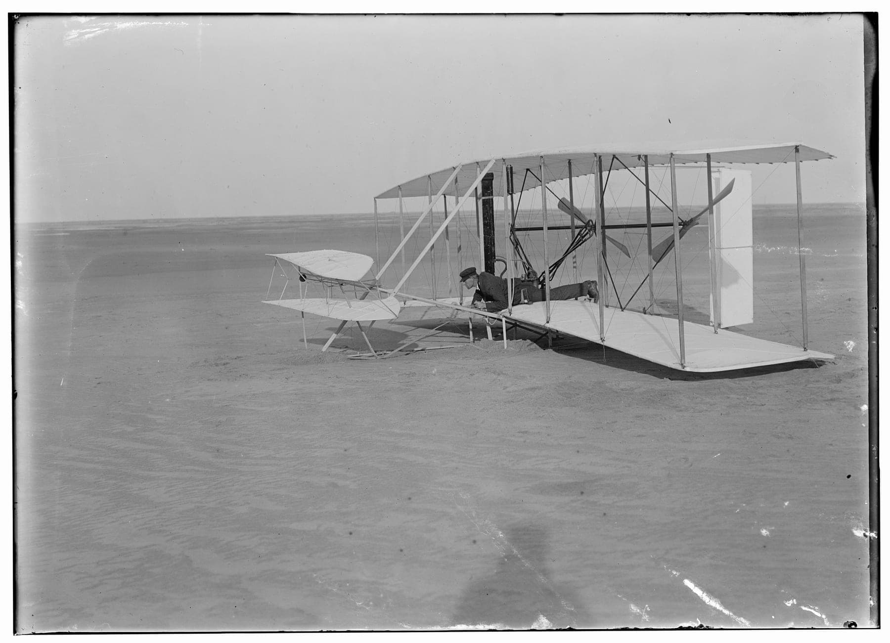 Wilbur Wright lying at the controls of the damaged machine after the failed attempt of 14 December 1903.