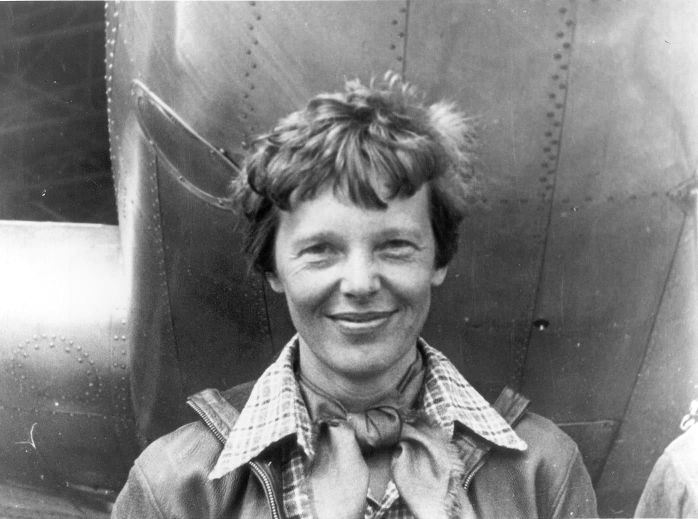 Amelia Earhart standing beneath the nose of her twin-engined Lockheed Electra 10-E in March 1937