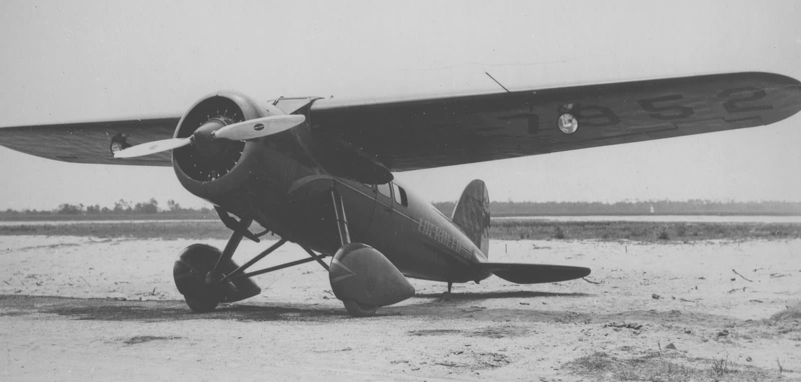Amelia Earhart's Lockheed Vega 5B, a high-wing monoplane with a round wooden fuselage, on the ground around 1932