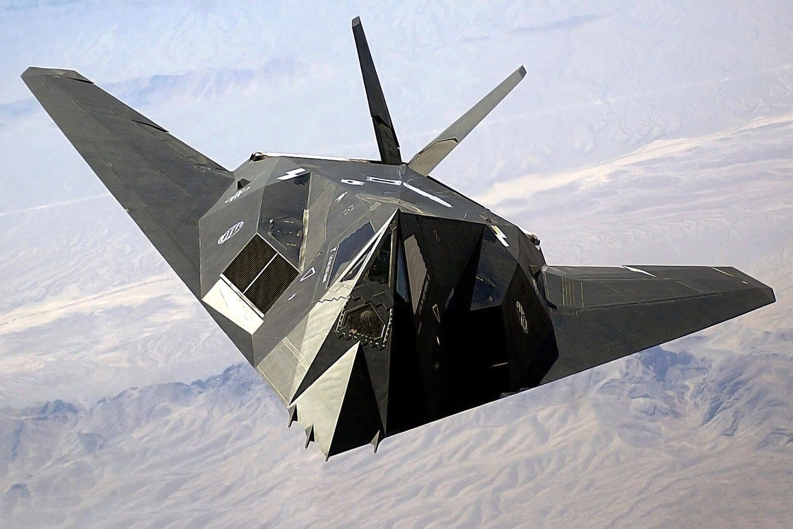 A faceted black Lockheed F-117A Nighthawk stealth aircraft in flight over Nevada in 2002