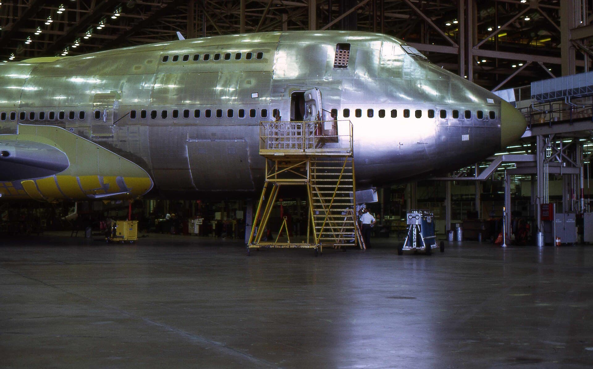 The Boeing Everett factory floor, a 747 fuselage under construction dwarfed by the volume of the building raised specifically to hold it