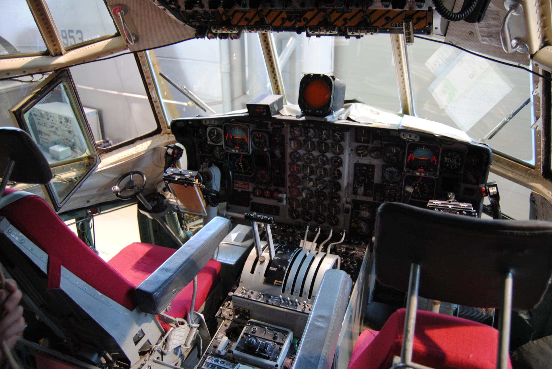 The classic analogue flight deck of a preserved C-130 Hercules, with the navigator's and flight engineer's stations behind the pilots