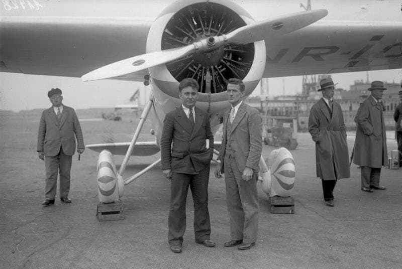 Wiley Post and Harold Gatty standing together during their round-the-world flight in June 1931